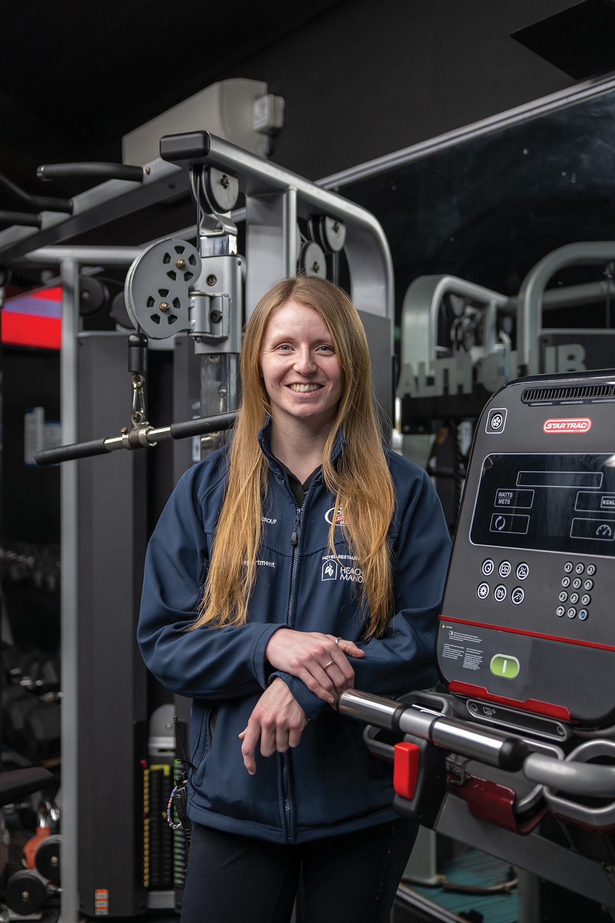 Female student in blue hoodie in a gym.